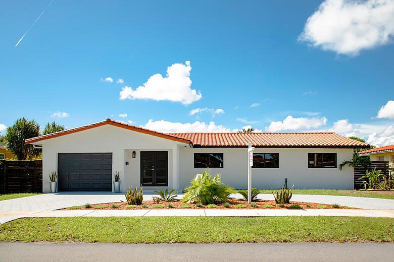 Impact window and sliding glass door installation by Elbaz Construction across South Florida: aluminium-framed impact glazing in stucco openings, on waterfront and single-storey homes
