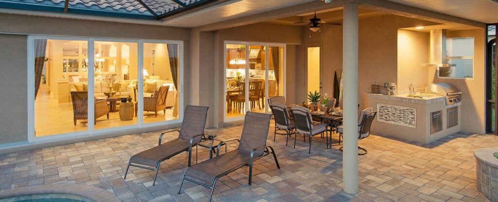 Impact window and sliding glass door installation by Elbaz Construction across South Florida: aluminium-framed impact glazing in stucco openings, on waterfront and single-storey homes