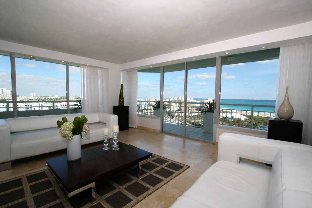 Impact window and sliding glass door installation by Elbaz Construction across South Florida: aluminium-framed impact glazing in stucco openings, on waterfront and single-storey homes