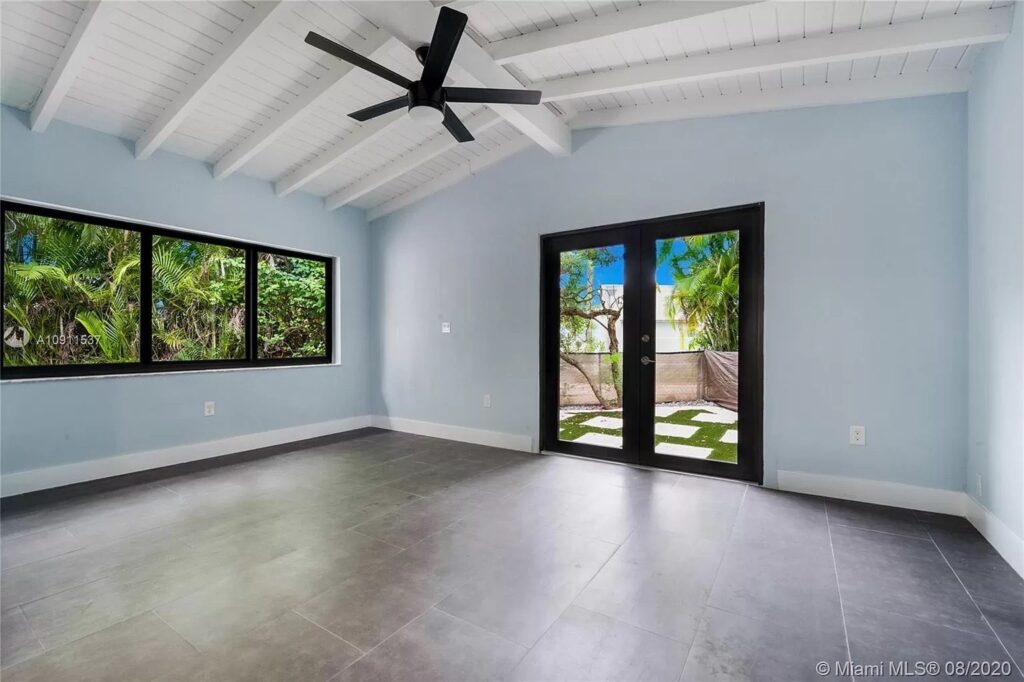 Impact window and sliding glass door installation by Elbaz Construction across South Florida: aluminium-framed impact glazing in stucco openings, on waterfront and single-storey homes