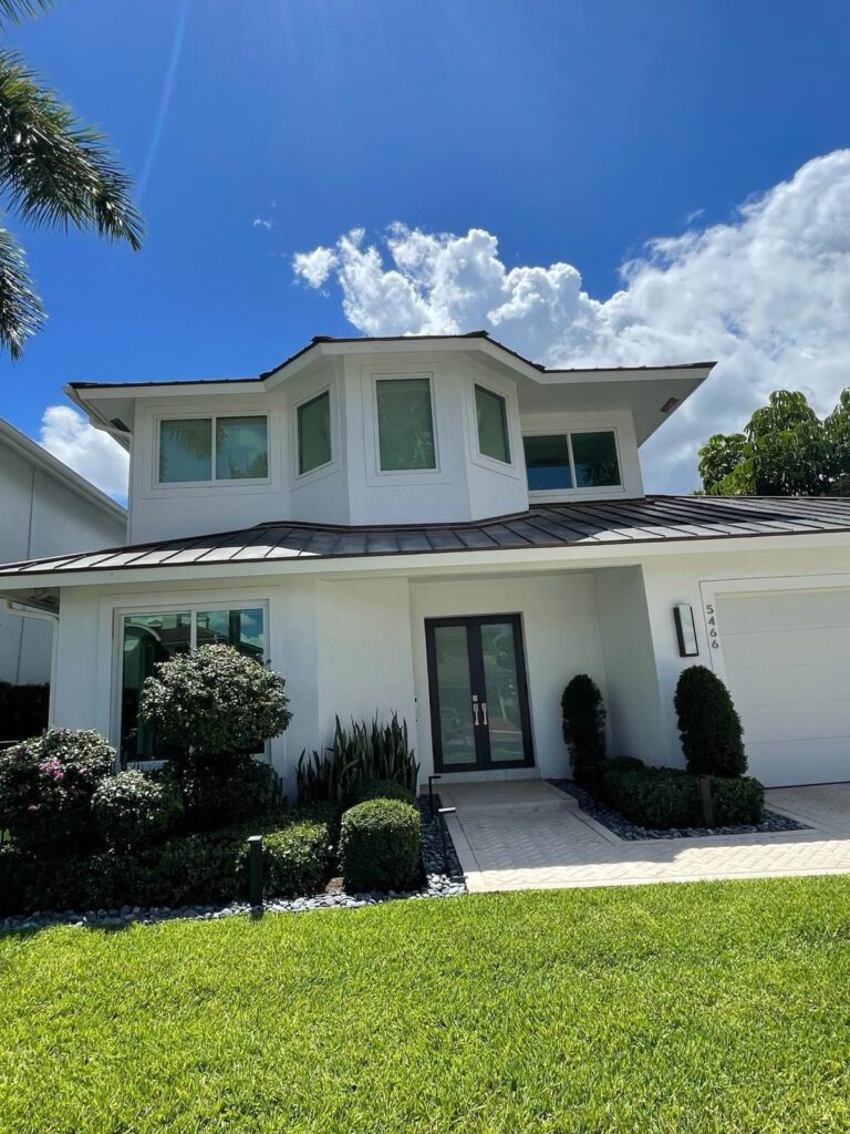 Impact window and sliding glass door installation by Elbaz Construction across South Florida: aluminium-framed impact glazing in stucco openings, on waterfront and single-storey homes