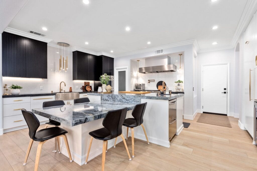 Island seating at the integrated quartzite dining top, with the fluted black upper bank behind