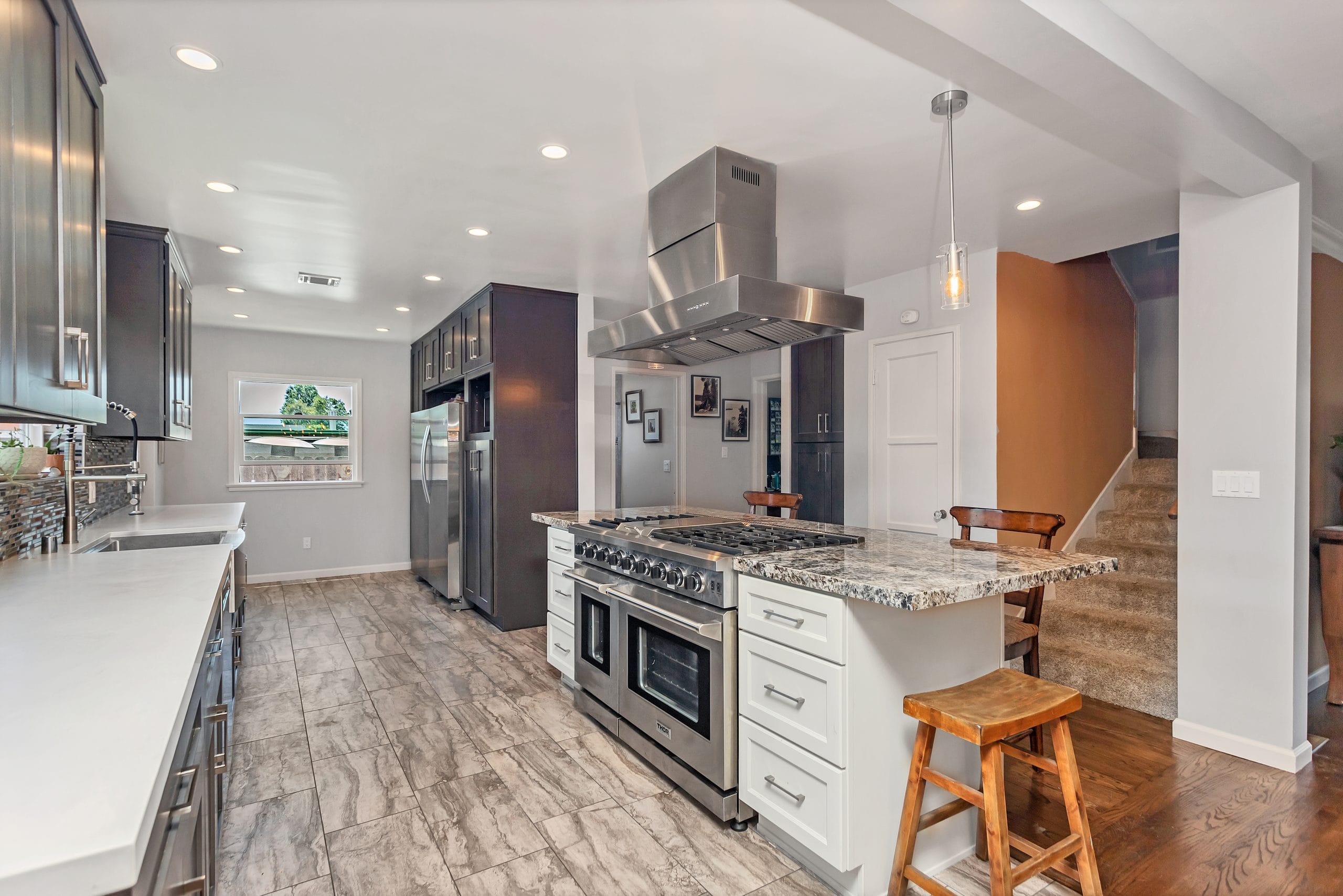 Kitchen from the far end: range, island hood and the island worktop running back towards the dining area