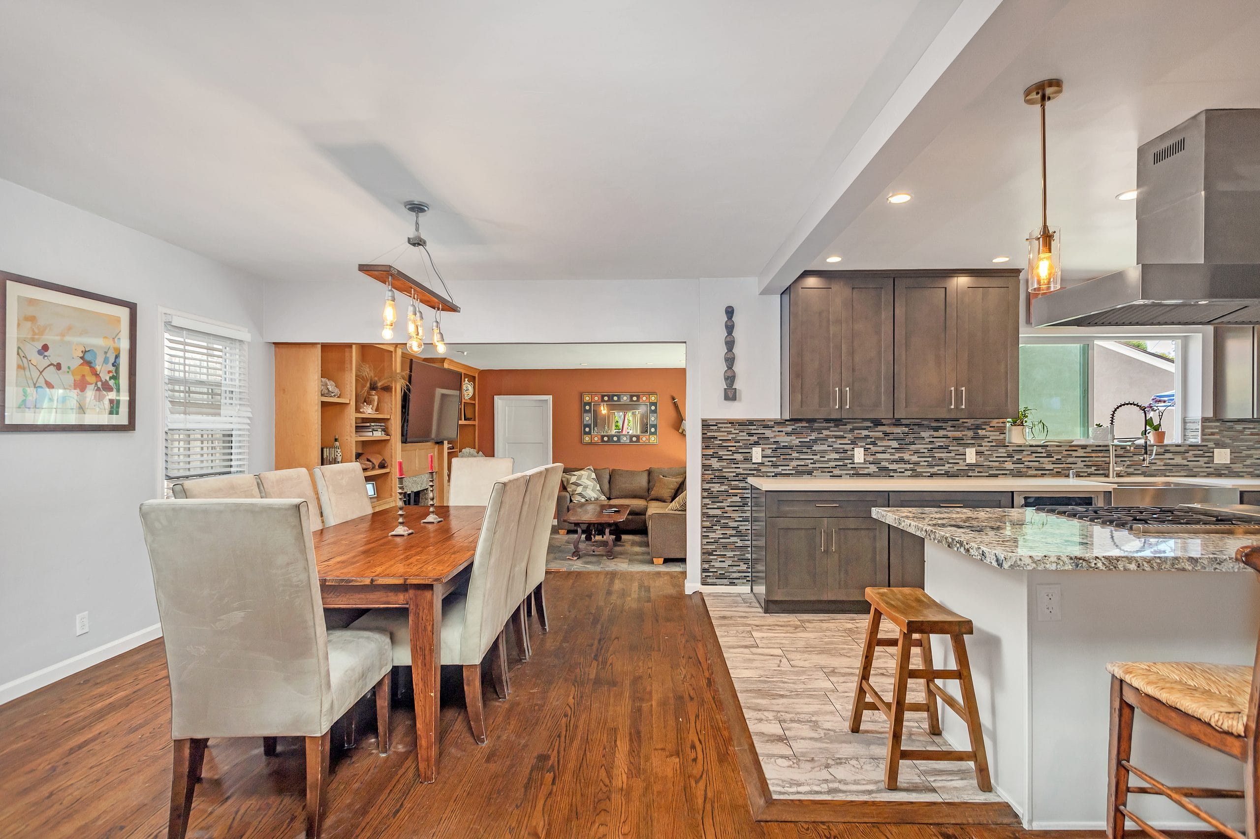 Completed kitchen open to the dining room, with the island seating and pendant lighting in use