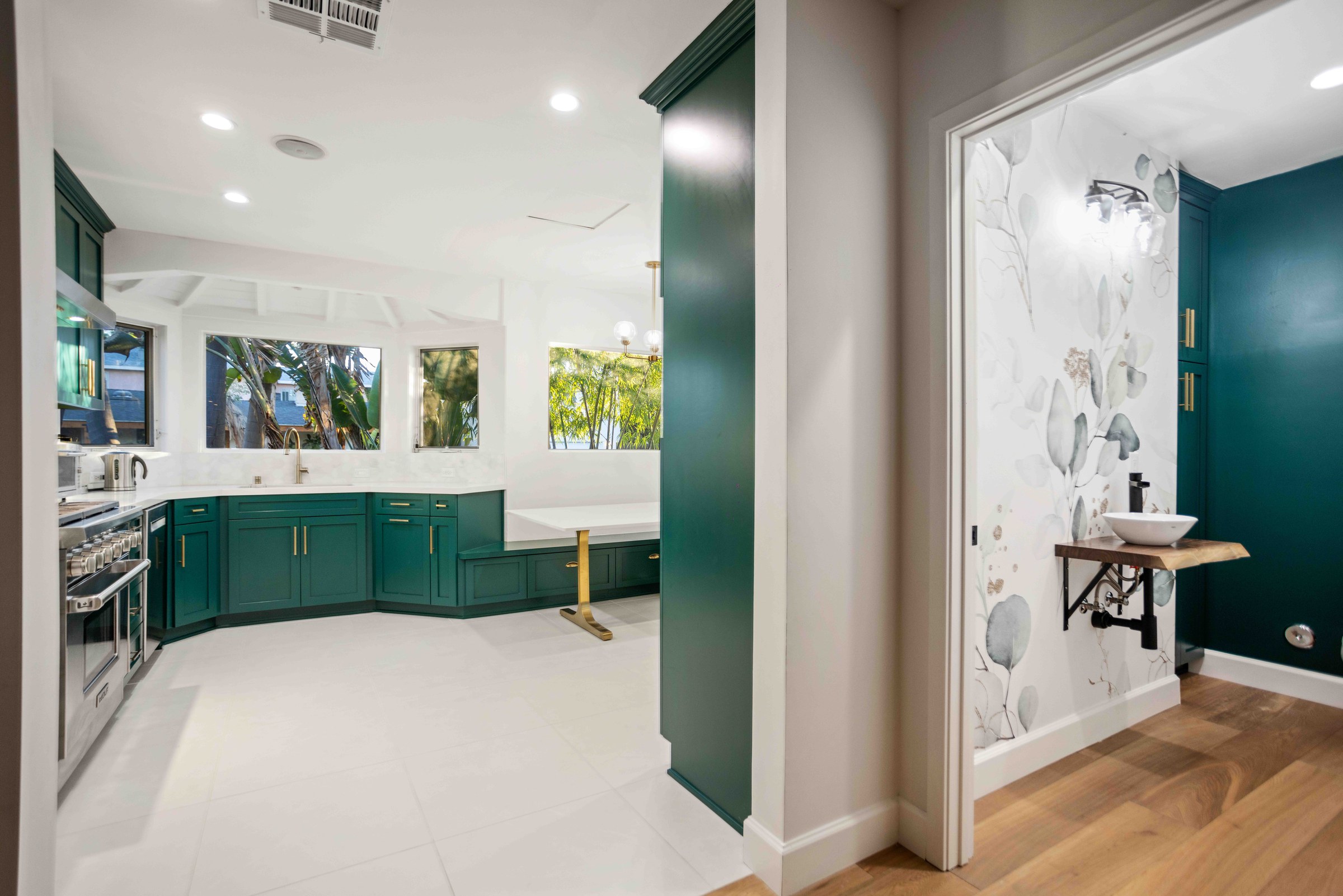 Emerald green shaker kitchen with a stainless professional range and white hexagon tile
