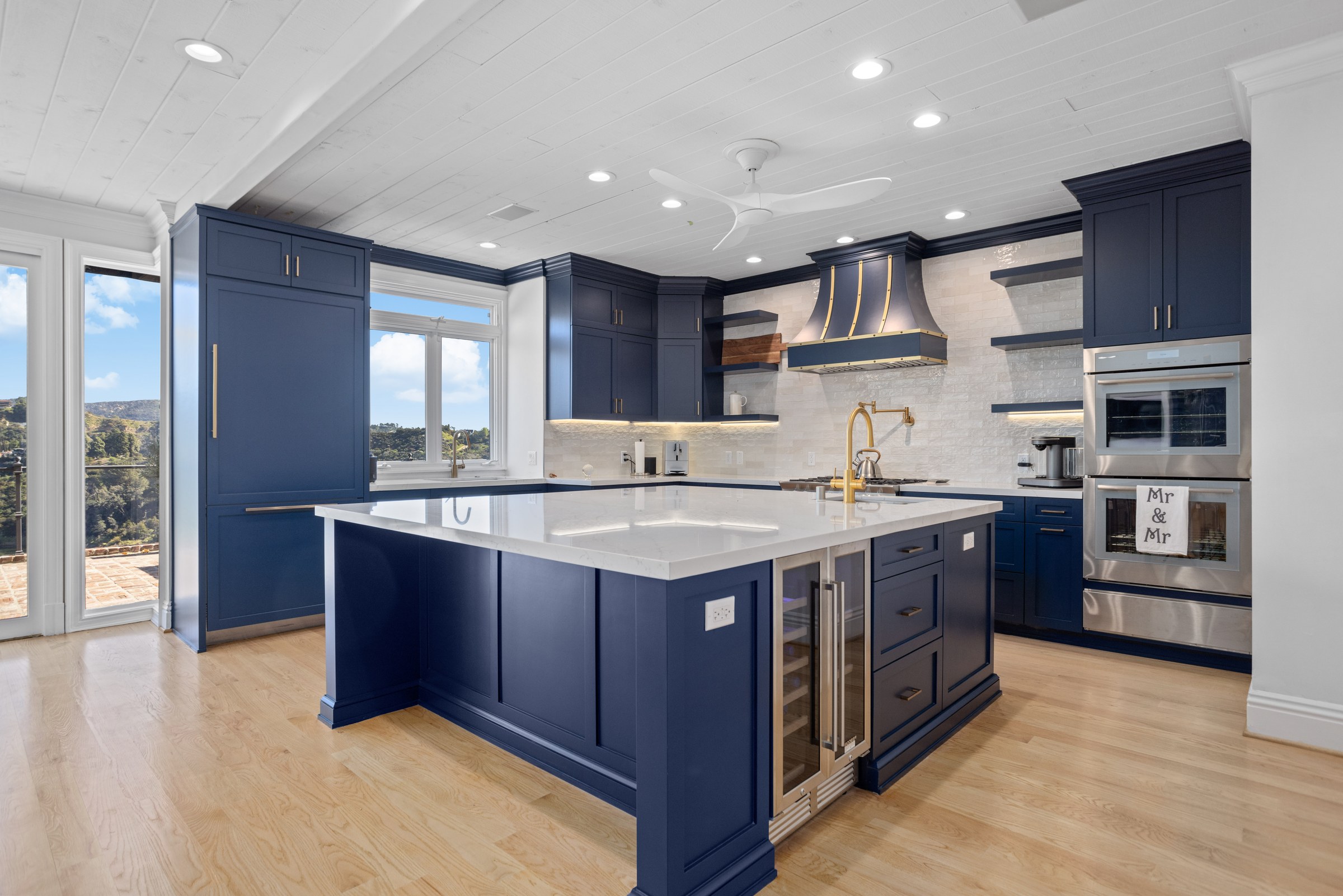 Navy Blue Shaker Kitchen with Brass Hardware and a Custom Range Hood
