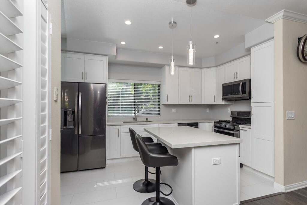 White Shaker Kitchen Remodel with Waterfall Quartz Island