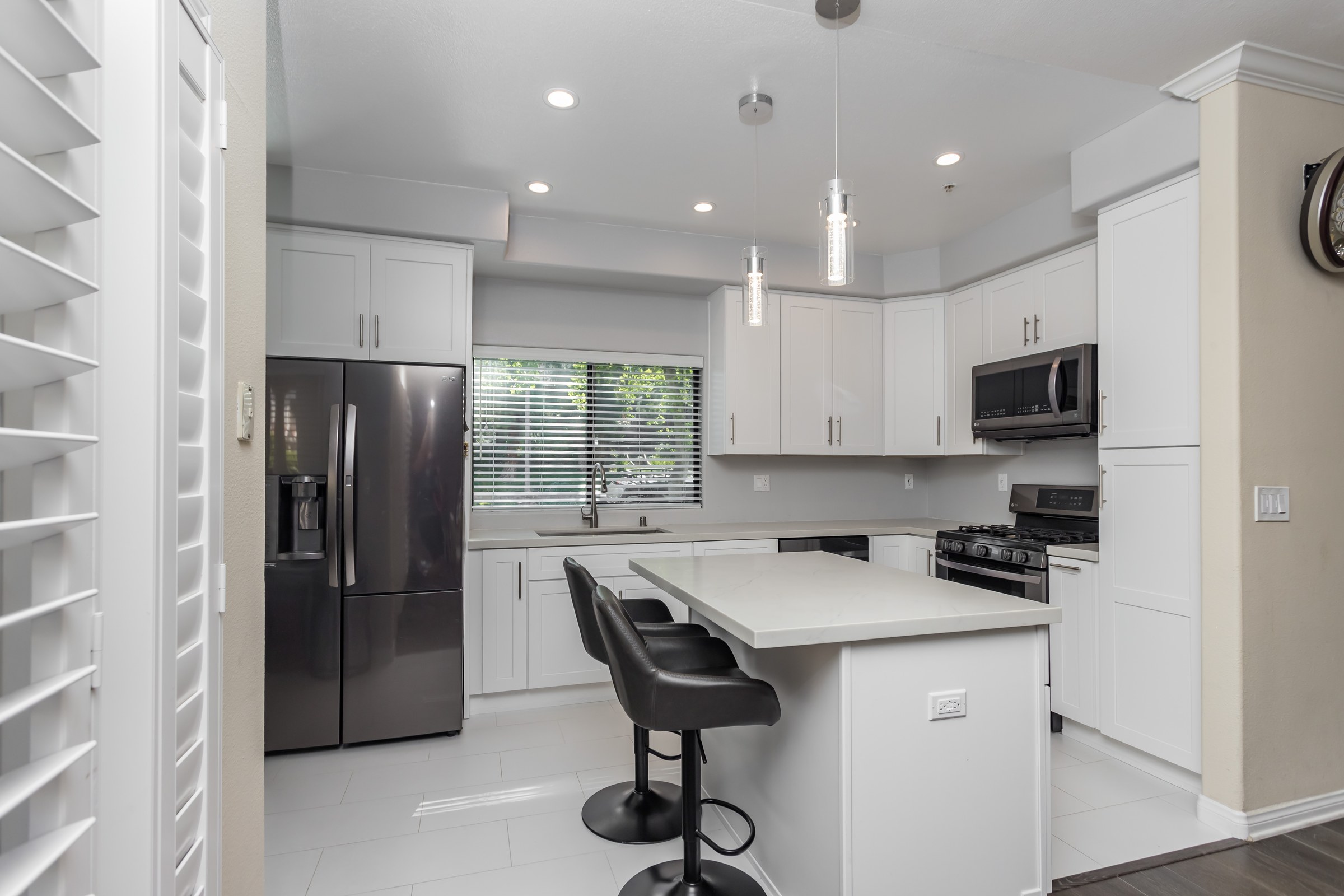 White Shaker Kitchen Remodel with Waterfall Quartz Island