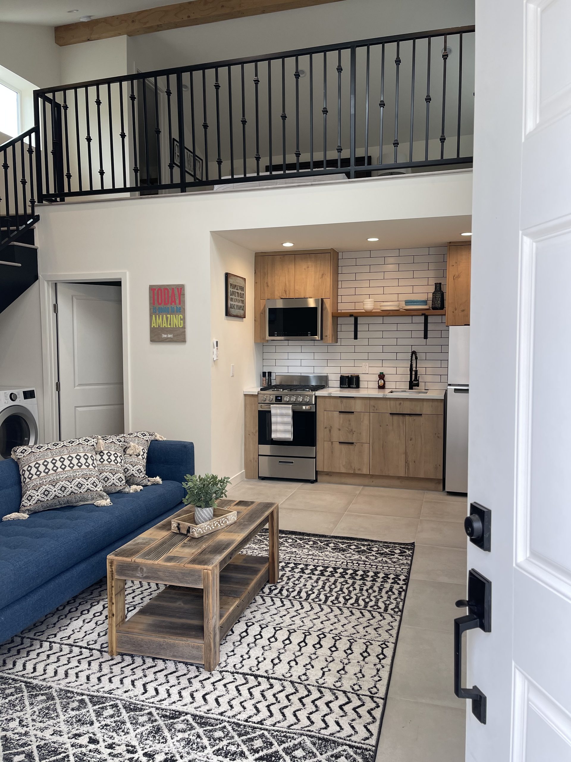 Interior of a two-storey Elbaz Construction ADU showing the living area, kitchenette and the stair up to the loft bedroom