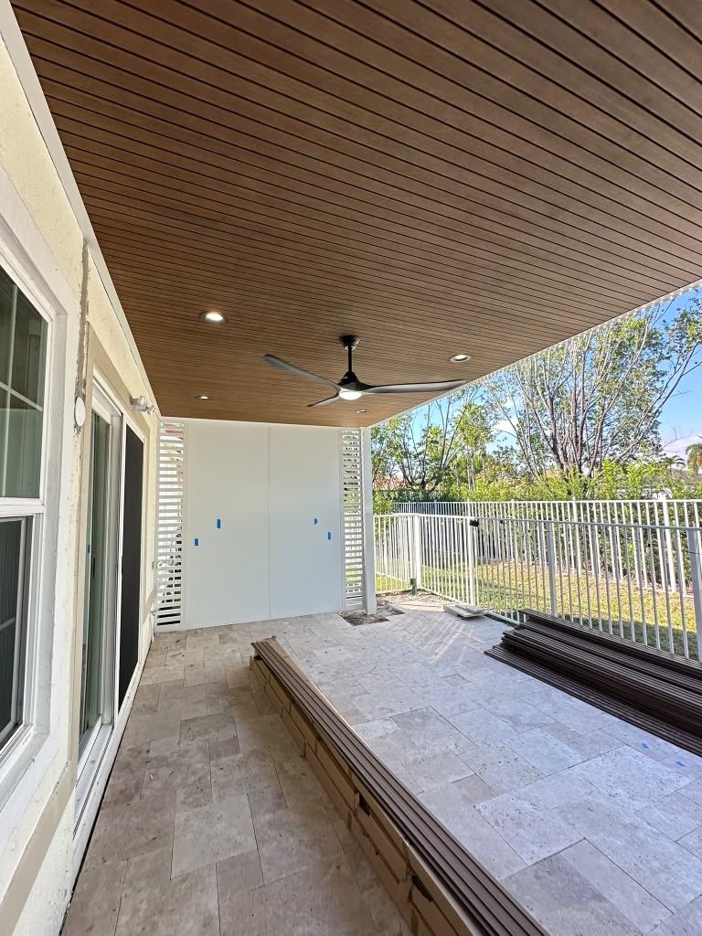Timber-clad soffit with recessed lighting and a ceiling fan over a terrace