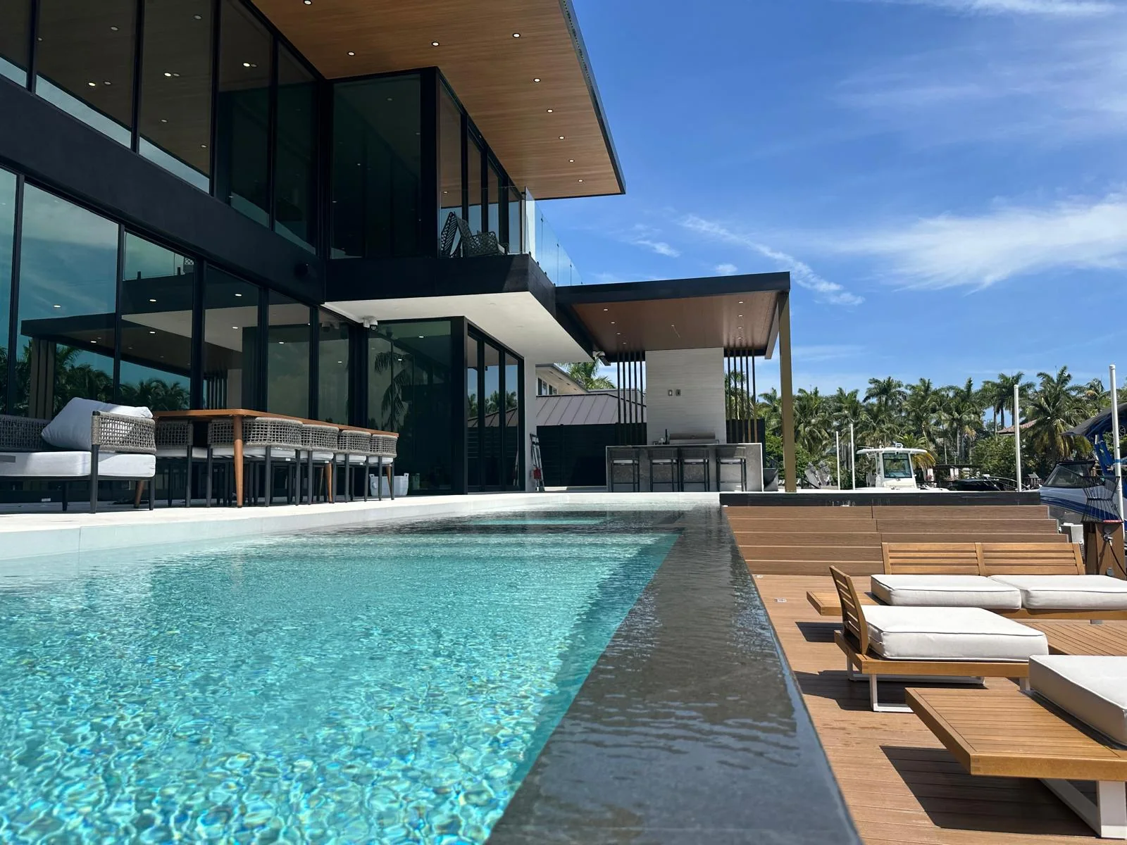 Modern flat-roof pergola beside a pool on a canal-front South Florida property