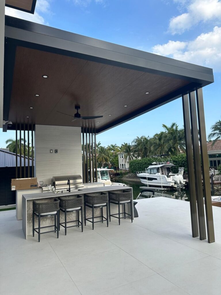 Pool deck and terrace flooring by Elbaz Construction in South Florida: travertine, large-format porcelain and poured concrete decks around residential pools, several on waterfront canal lots