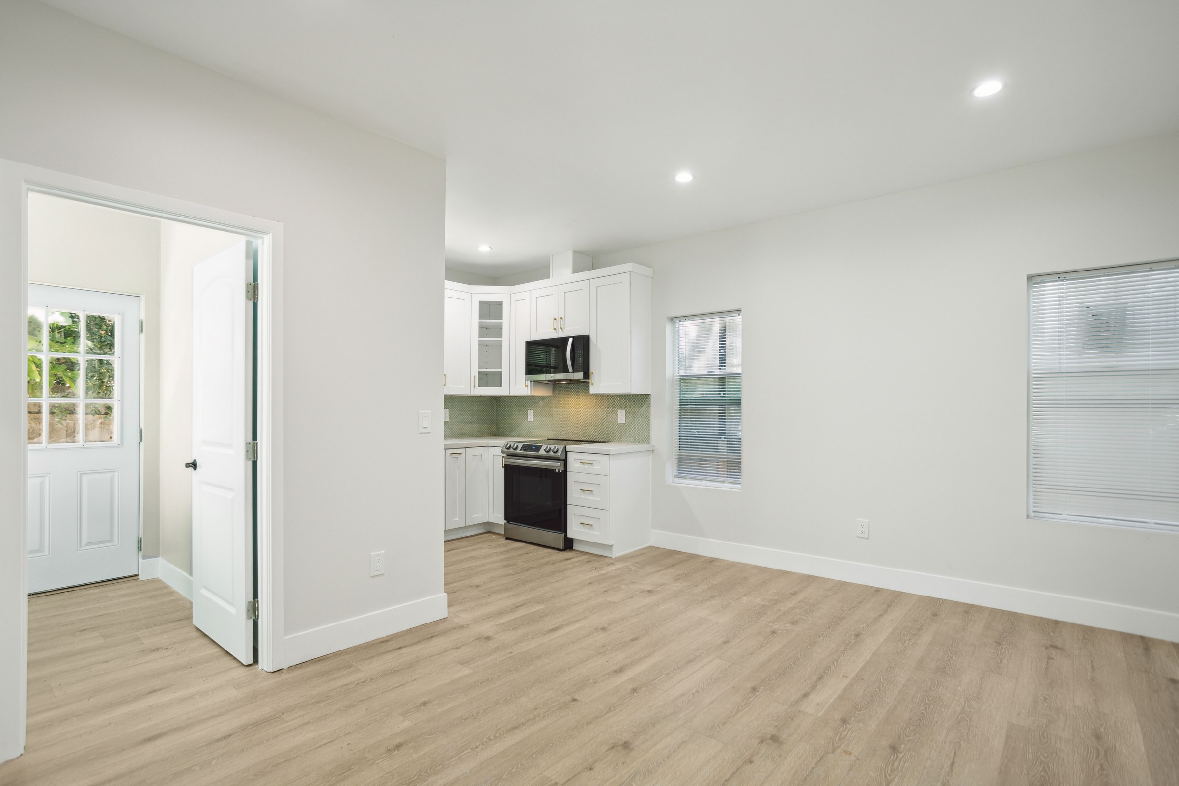 Garage converted into a studio ADU with a white shaker kitchenette and wide-plank flooring