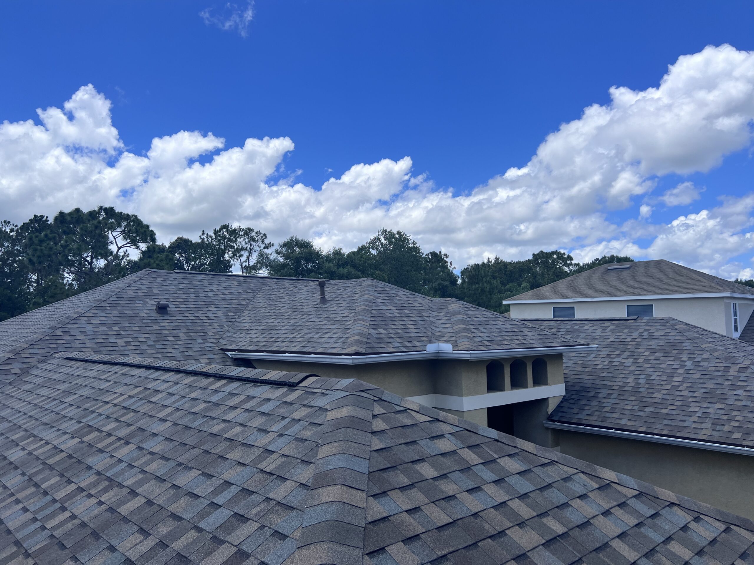 Newly completed shingle roof on a South Florida home under a clear sky