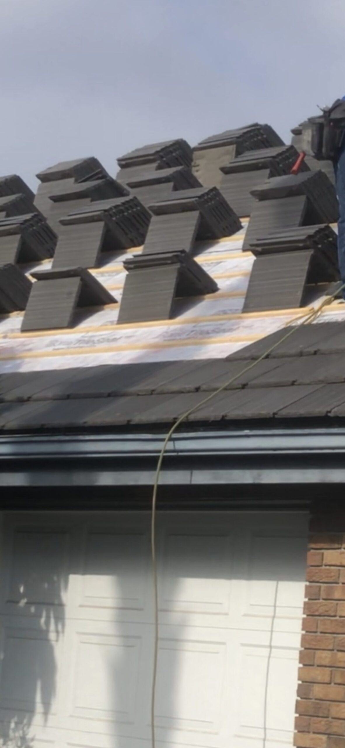 Shingle bundles staged on a roof slope before installation