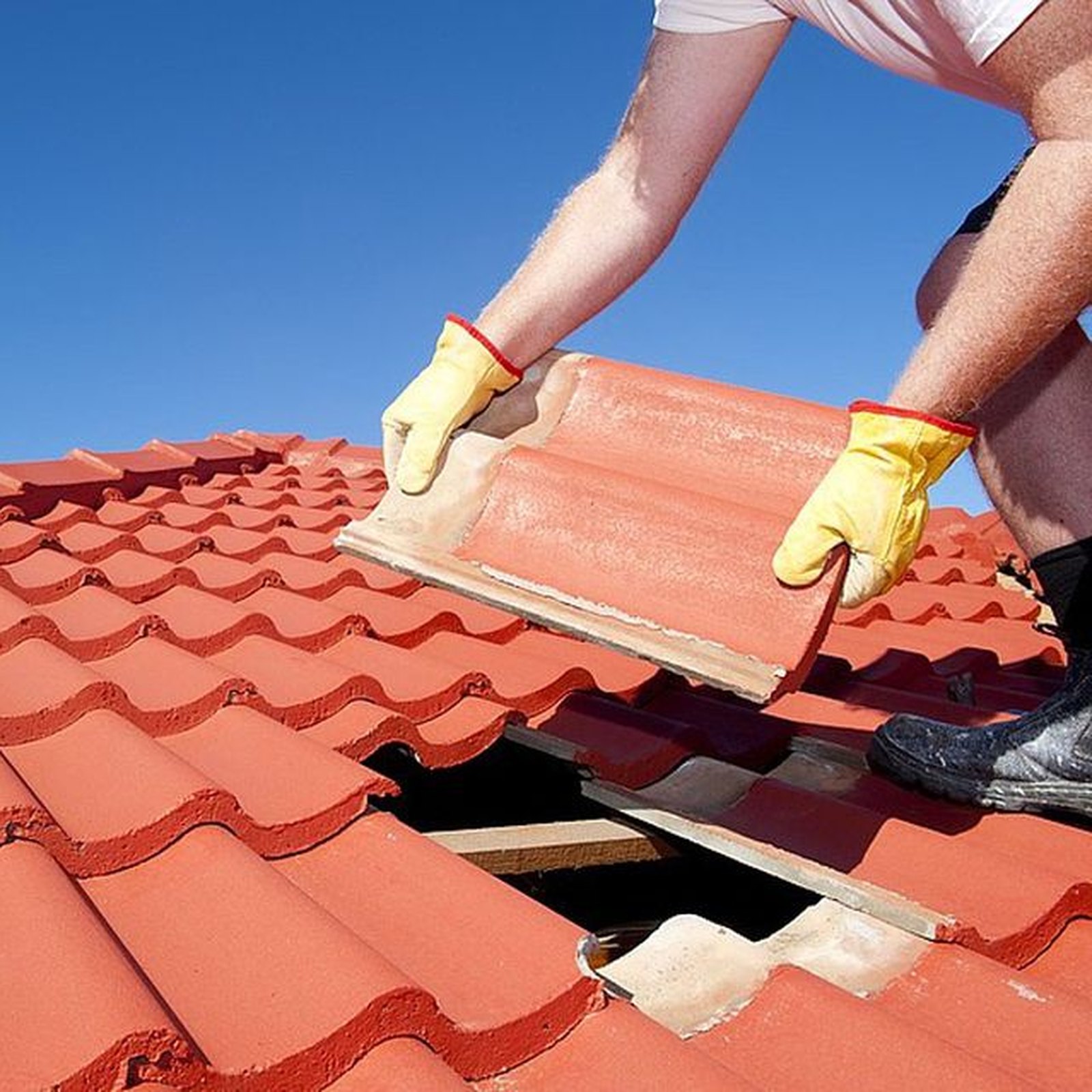 Roofing contractor installing clay tile roofing