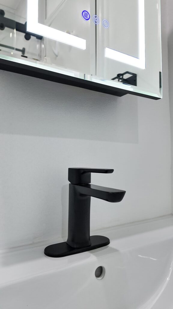 Compact bathroom remodel by Elbaz Construction with large-format marble-look porcelain, a fish-scale mosaic shower floor, matte black fixtures and a fluted oak vanity