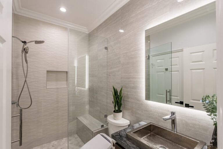 Narrow bathroom remodel by Elbaz Construction with textured wave-pattern wall tile, a walk-in shower with bench and niche, a backlit mirror and a floating vanity