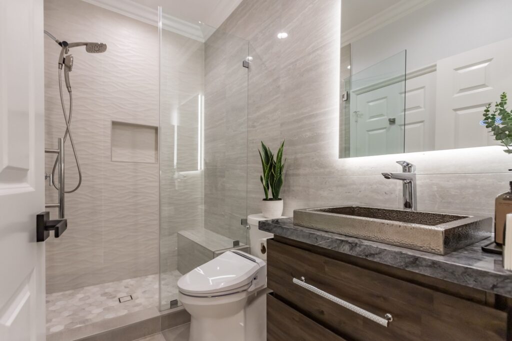 Narrow bathroom remodel by Elbaz Construction with textured wave-pattern wall tile, a walk-in shower with bench and niche, a backlit mirror and a floating vanity