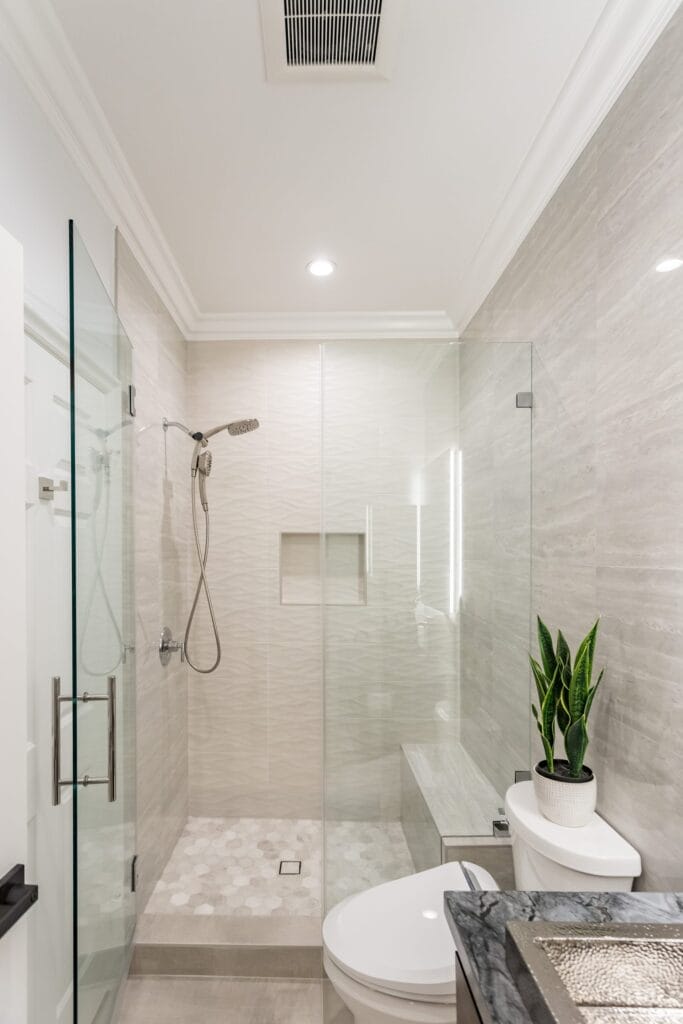 Narrow bathroom remodel by Elbaz Construction with textured wave-pattern wall tile, a walk-in shower with bench and niche, a backlit mirror and a floating vanity
