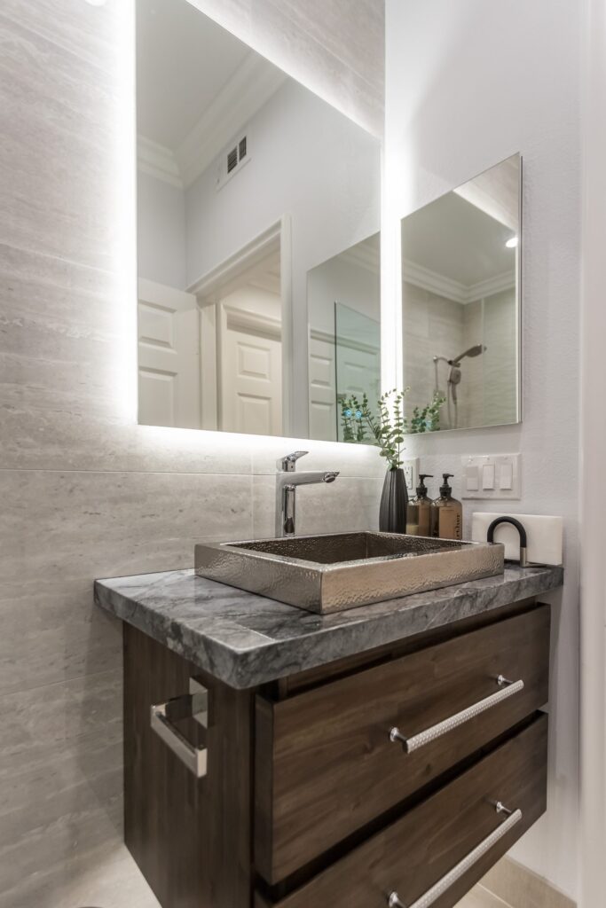 Narrow bathroom remodel by Elbaz Construction with textured wave-pattern wall tile, a walk-in shower with bench and niche, a backlit mirror and a floating vanity