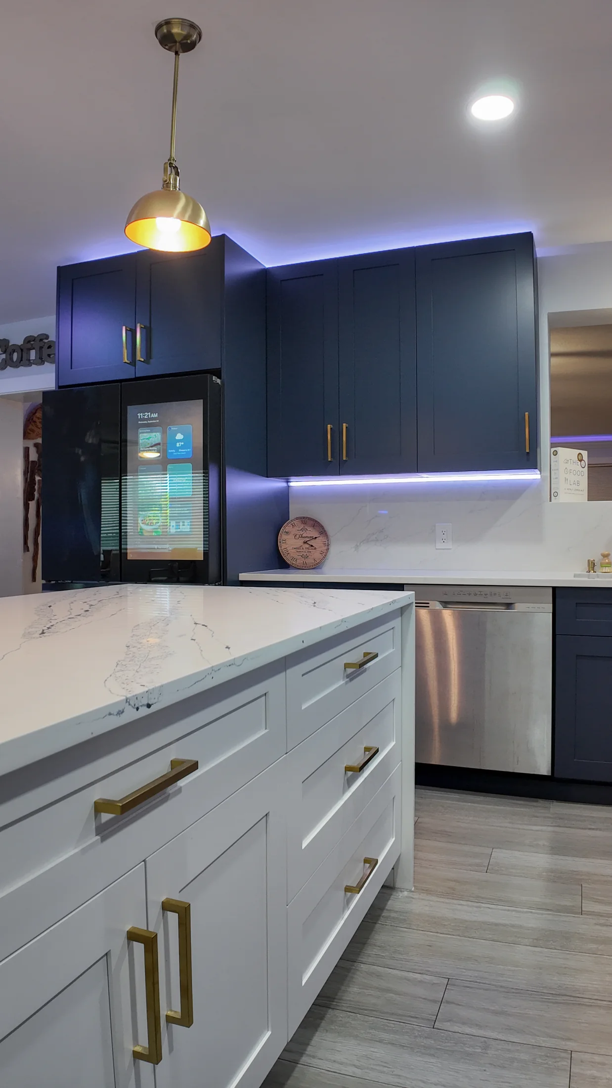 Tall refrigerator and cabinet run at the end of a compact kitchen