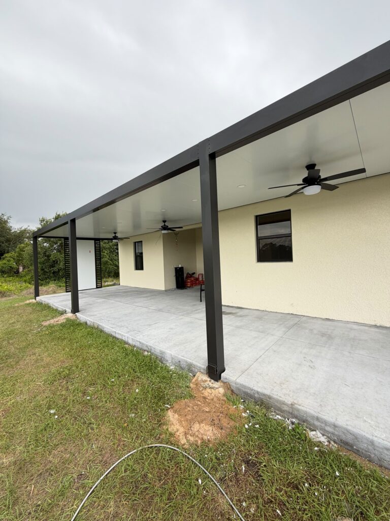 Painted stucco elevations on South Florida houses photographed on Elbaz Construction project sites: single and two-storey rendered walls with barrel-tile and flat roofs