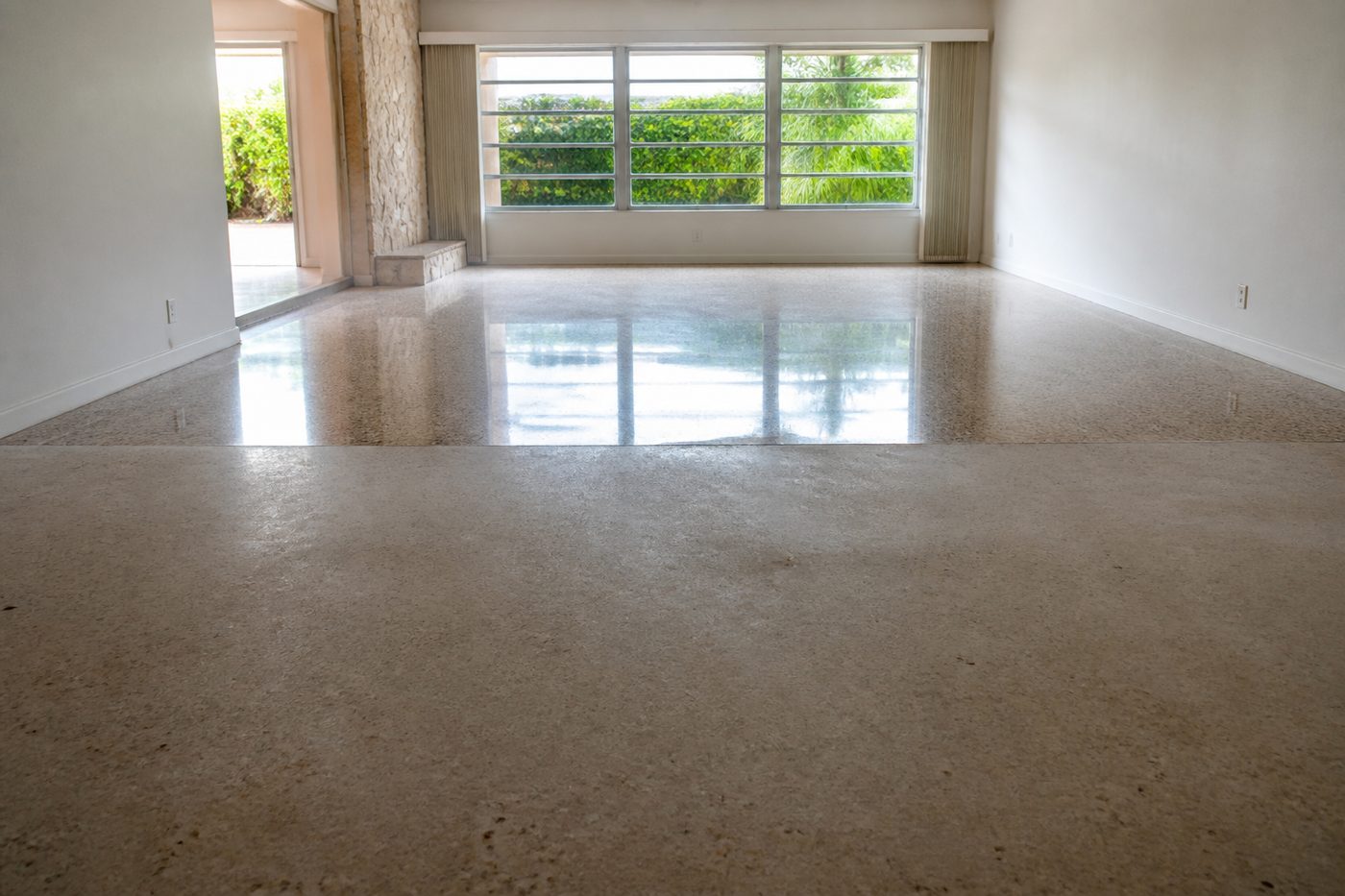 AI-generated illustration: a terrazzo floor mid-restoration, showing the dull worn surface on one side and the ground and polished surface on the other