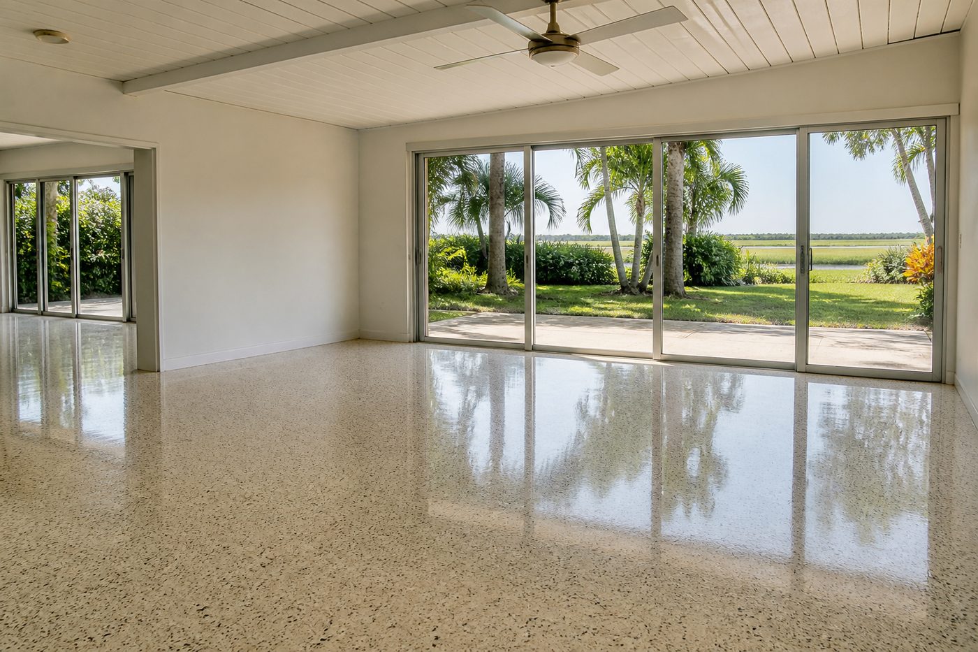 AI-generated illustration: a restored terrazzo floor in an empty sunlit room, reflecting daylight from a glazed wall