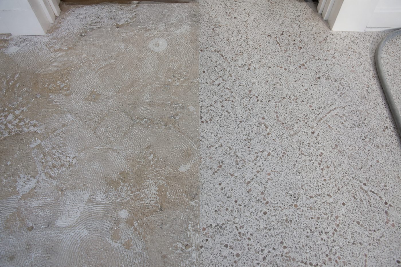 AI-generated illustration: terrazzo part-way through restoration, adhesive residue on one side and clean exposed aggregate on the other