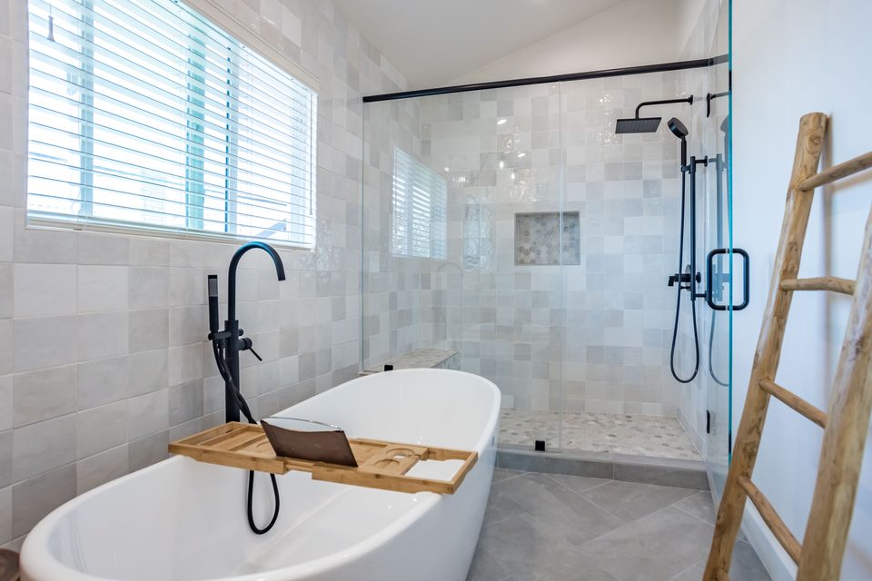 Bathroom with freestanding tub, black fixtures and tiled shower