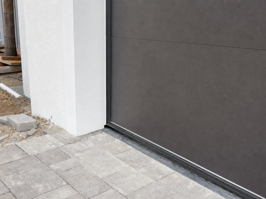 Illustration of the bottom seal of a sectional garage door meeting a concrete slab