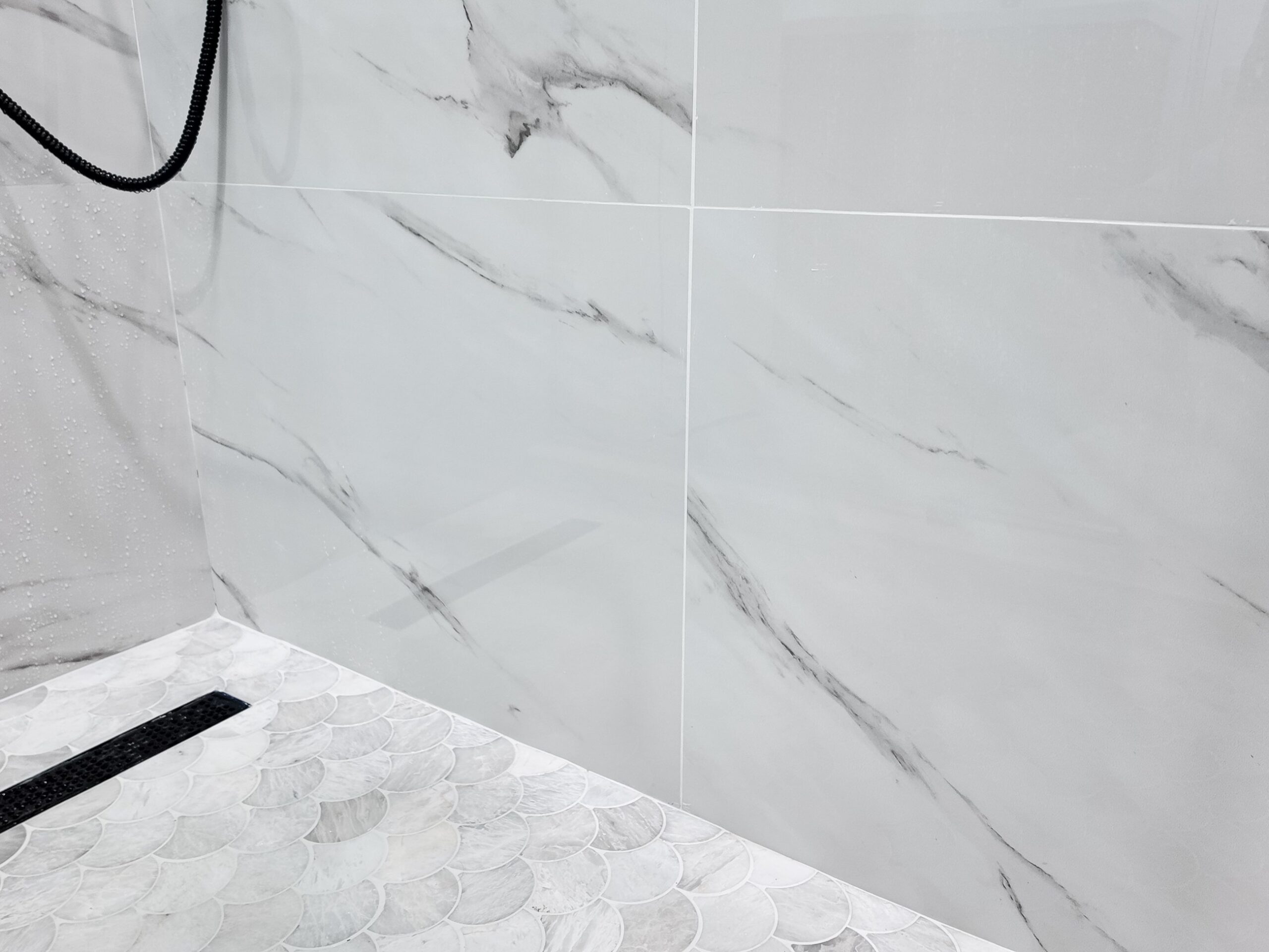 Large-format marble-look porcelain wall panels with the veining running continuously across the joints