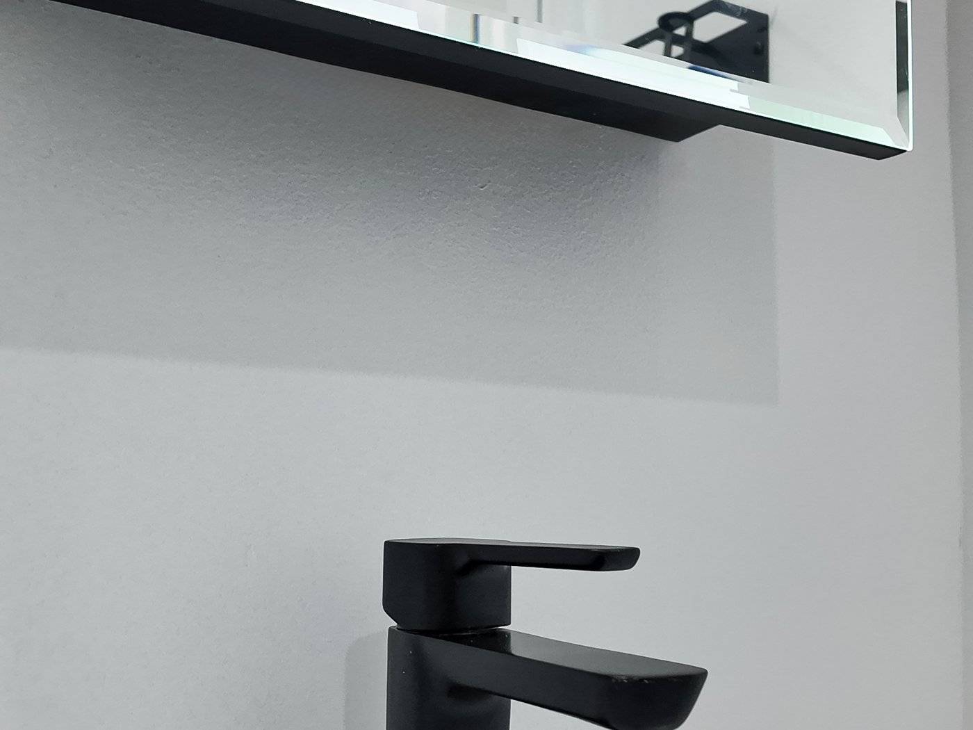 Matt black single-lever basin mixer on a white basin top