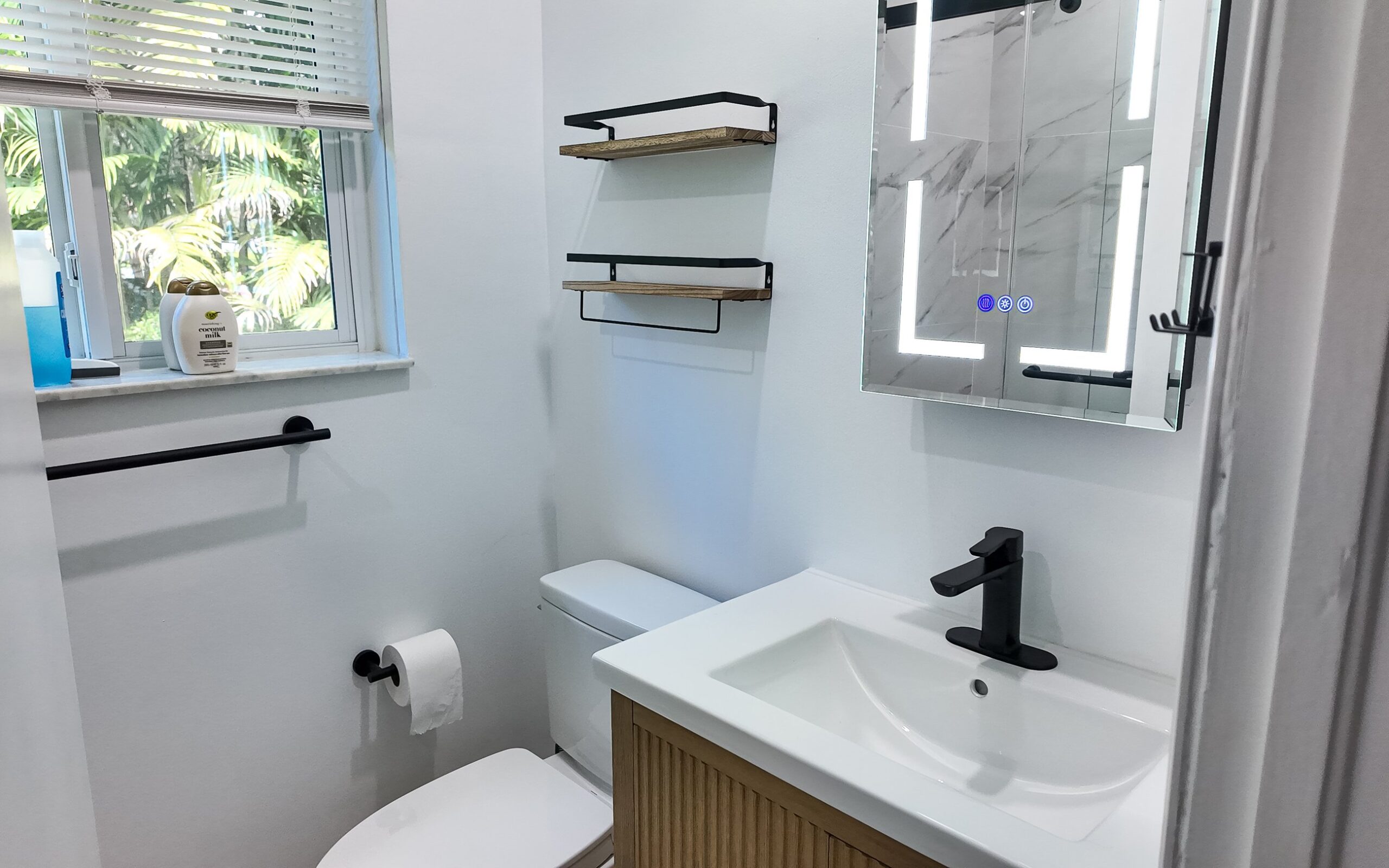 Vanity, mirror and shelving seen from the doorway of the finished bathroom