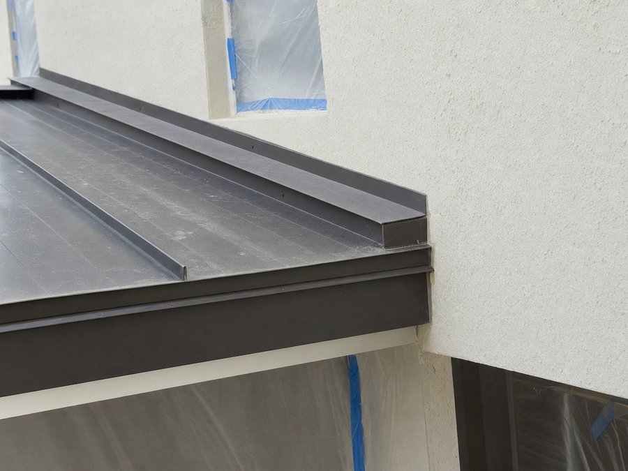 Illustration of metal roof-to-wall flashing with a counter-flashing let into the stucco above the panel upstand