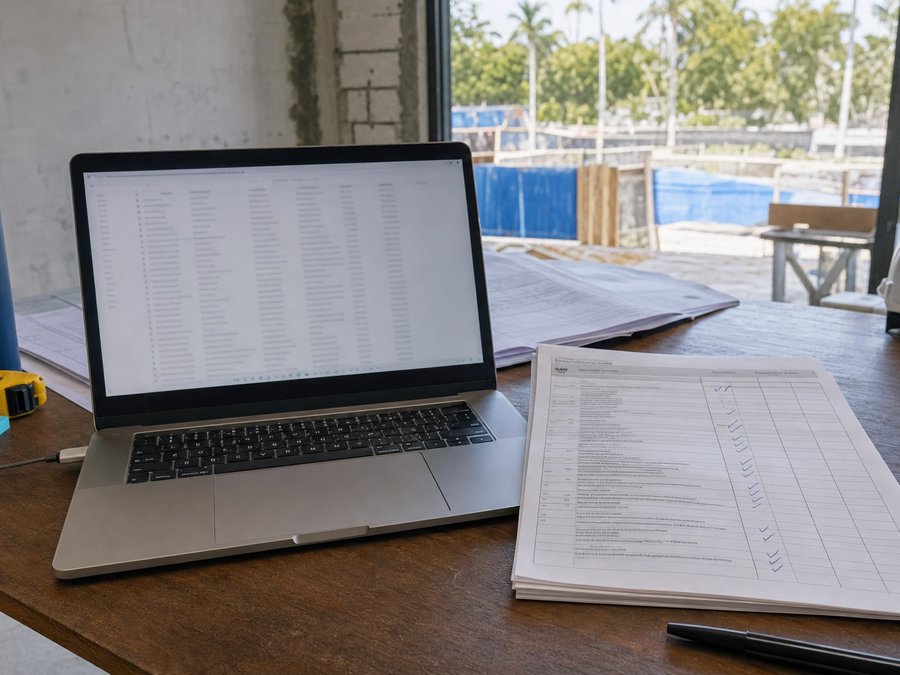 Illustration of a laptop and printed tracking sheet used to monitor open permit review comments