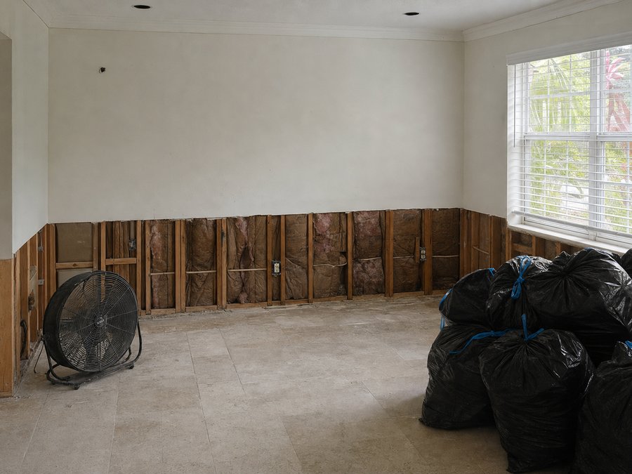 Illustration of water-damaged drywall cut away to a level line exposing the studs behind