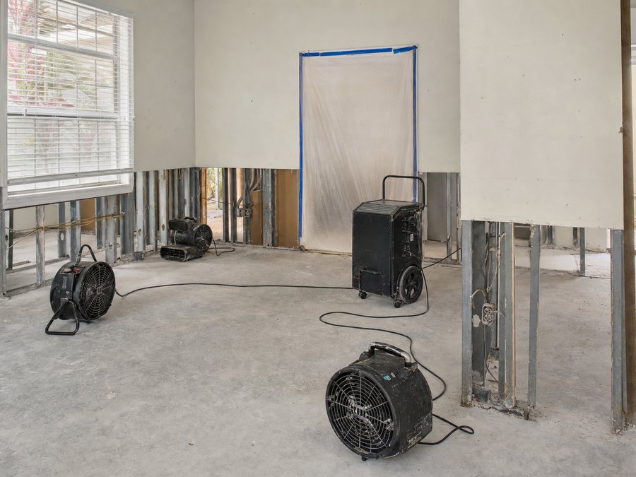 Illustration of air movers and a dehumidifier running in a stripped interior room